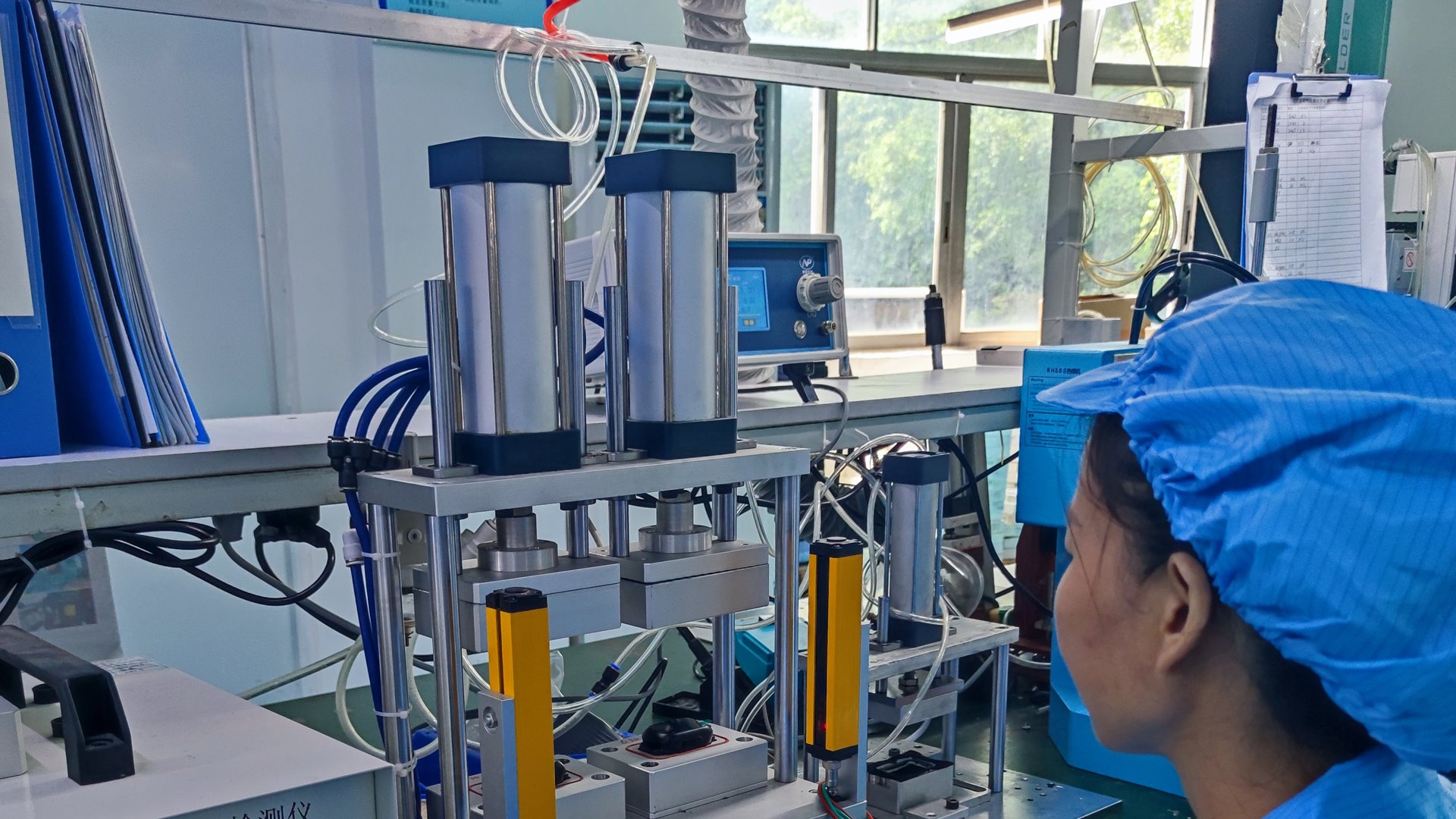 Operator running an air-leak tightness test at a smart pet appliance production line test station