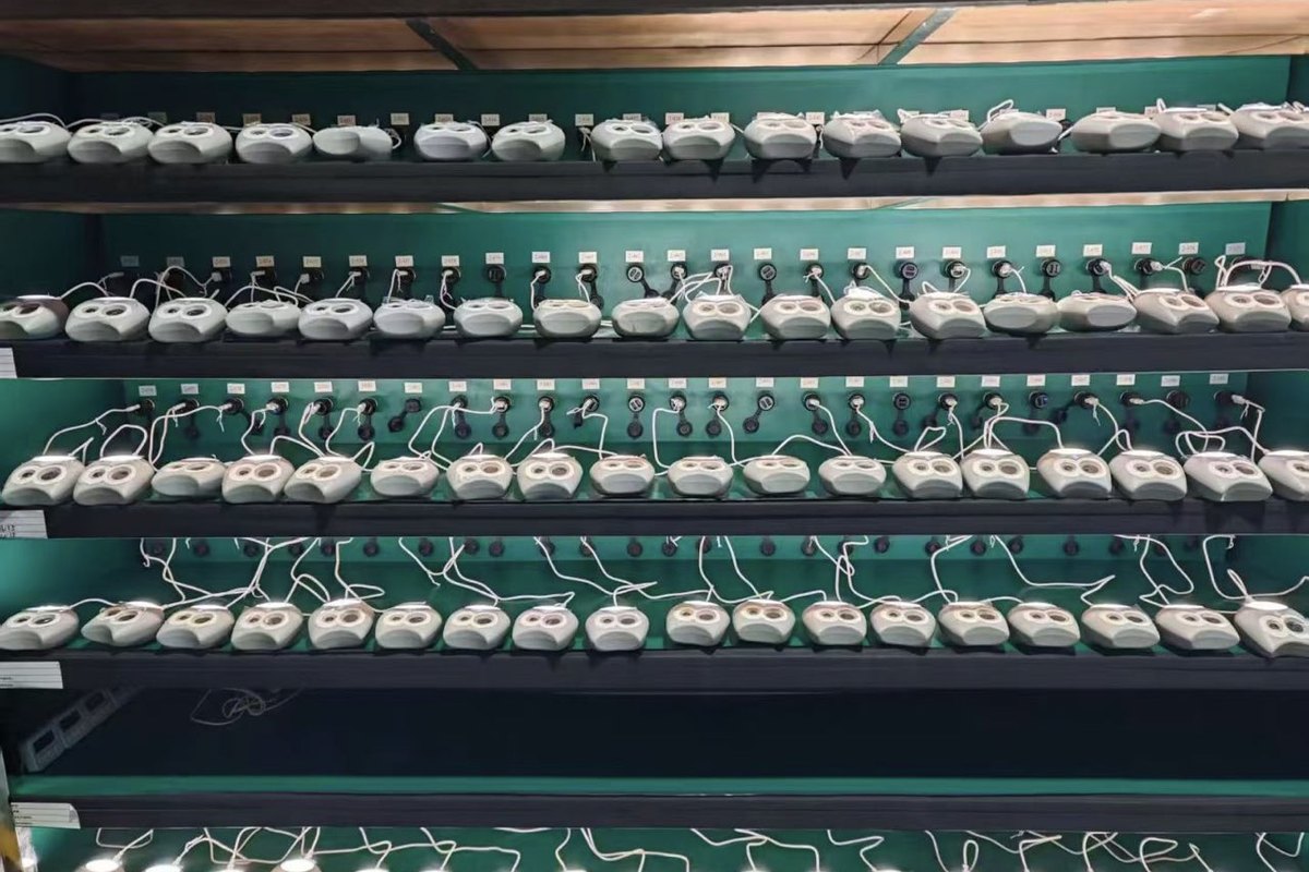 Rows of assembled pet product units staged for functional test, with control boards and connectors visible